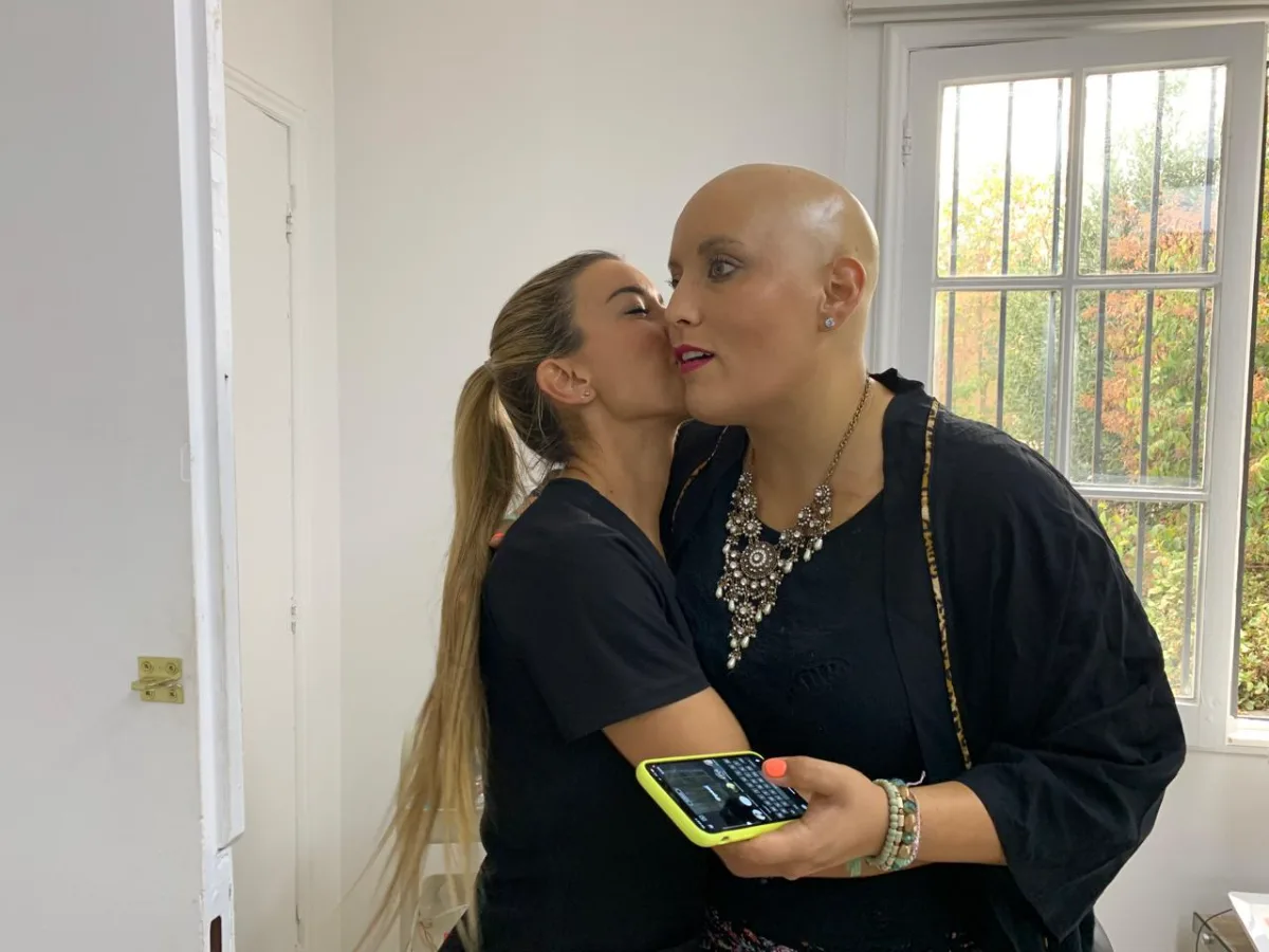 Una integrante de FEMPO abraza y besa en la mejilla a una paciente durante su tratamiento