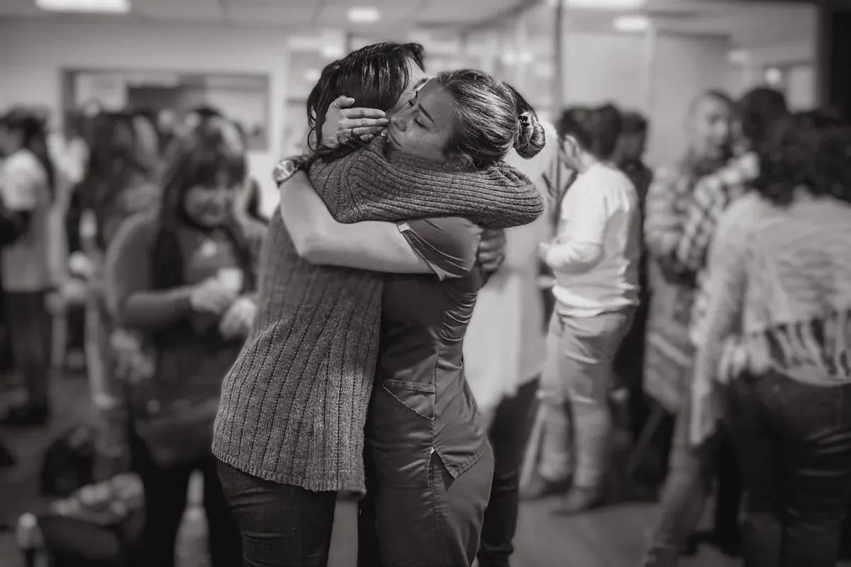 Una mujer abraza a otra en una jornada de la Fundación Fempo